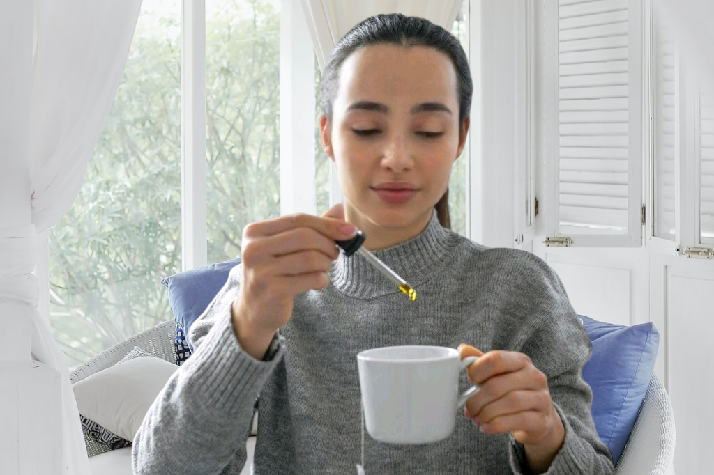 lady putting CBD drop in a cup